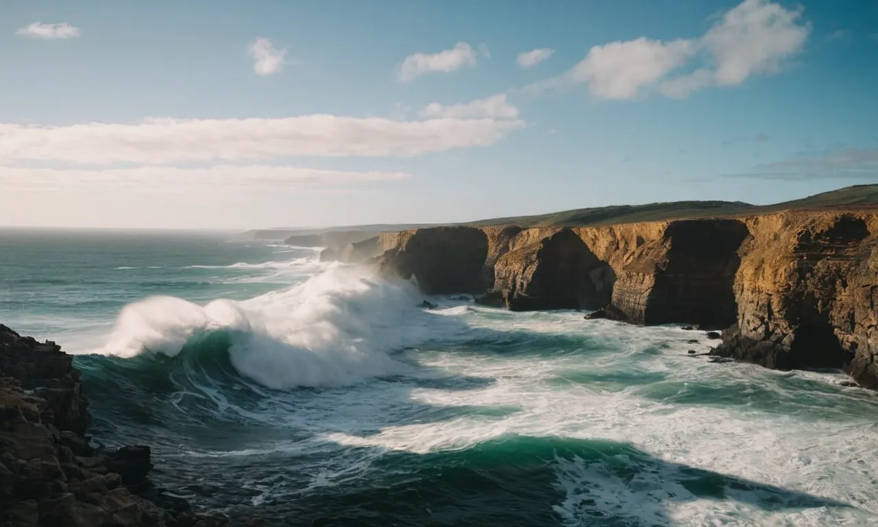 A powerful image capturing the vastness of the ocean, as waves crash against rugged cliffs, symbolizing the awe-inspiring creation of God described in the Bible.