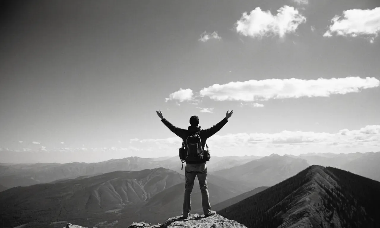 A black and white photo captures a person standing alone on a mountaintop, arms outstretched, looking up at a breathtaking sky, symbolizing the longing for guidance and purpose that leads us to question the need for God.